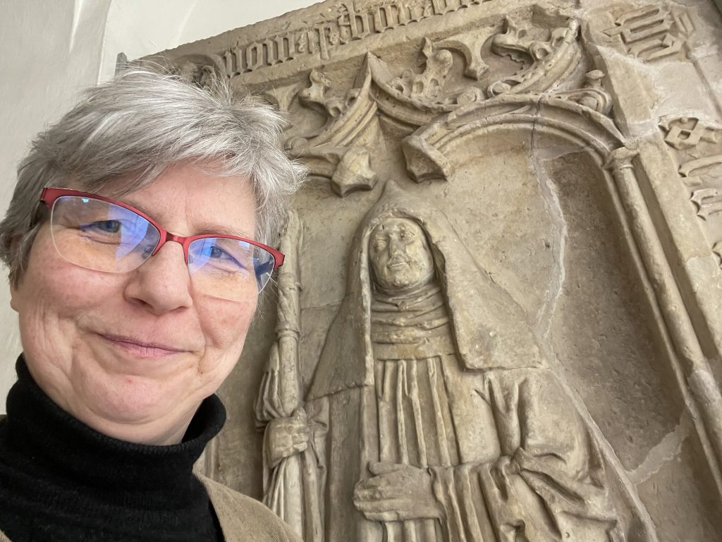 selfie with glasses in front of stone epitaph