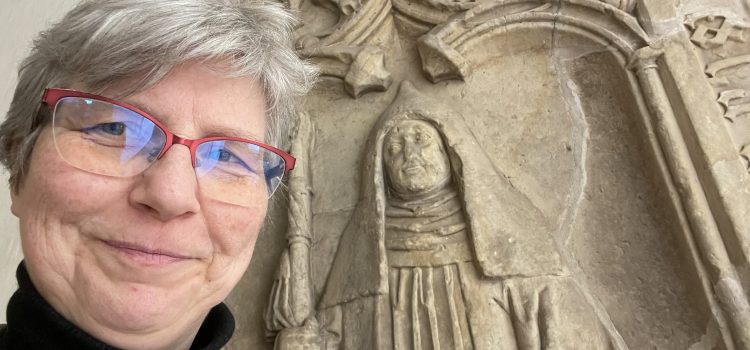 selfie with glasses in front of stone epitaph